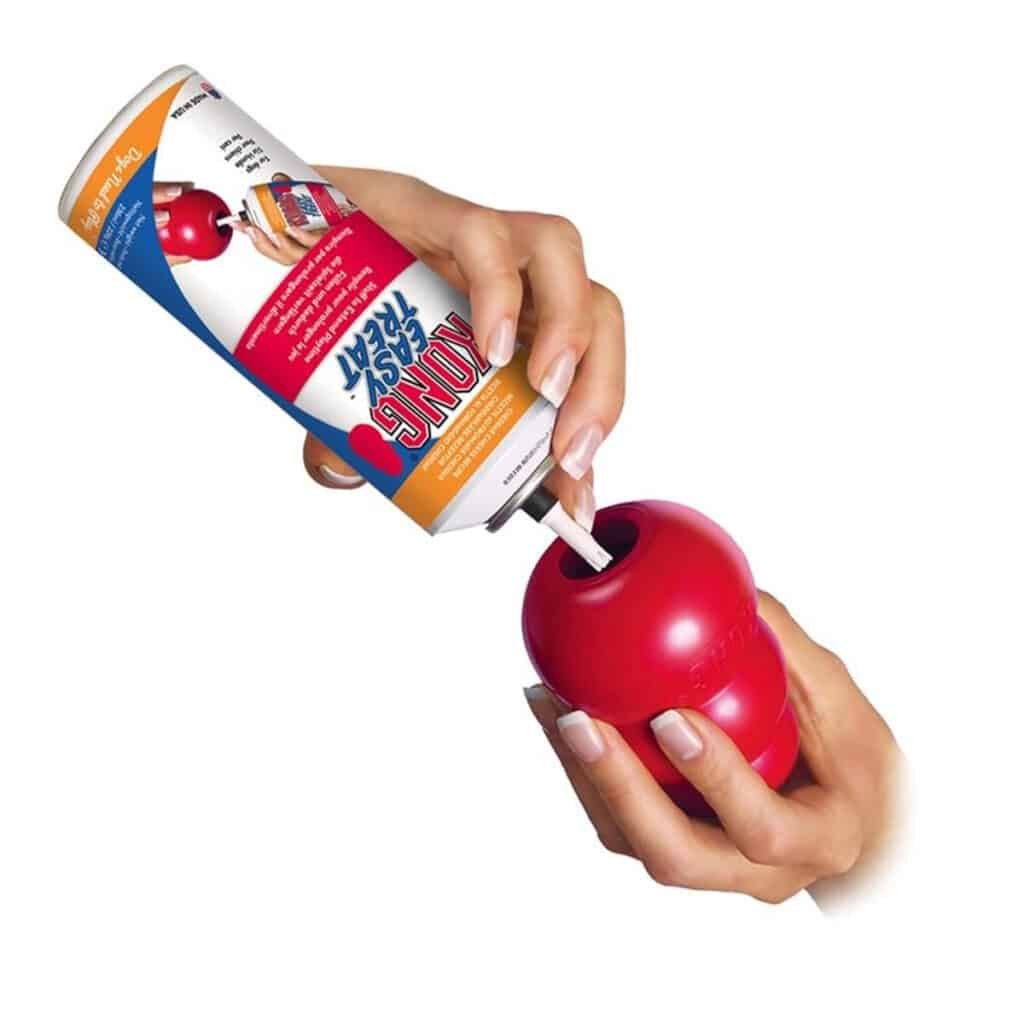 Main qui garnit un KONG Classic avec la pâte KONG Easy Treat en bombe