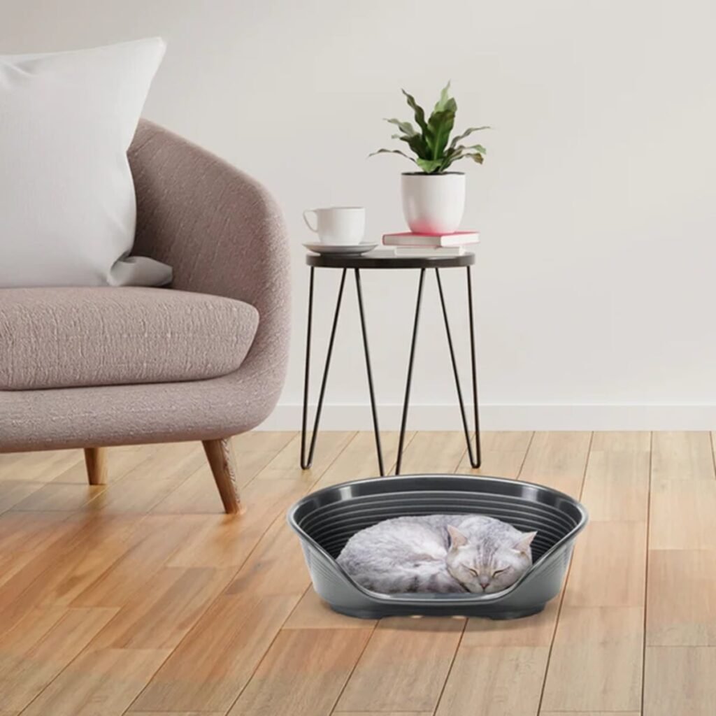 Chat endormi sur un coussin dans la corbeille Ferplast Siesta Deluxe posée dans un salon